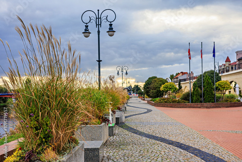 A boulevard with beautiful flower beds and trees on the banks of the river. photo