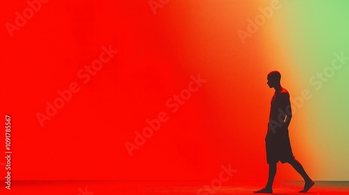 Silhouette of Person Walking Against Vivid Red and Green Gradient Background