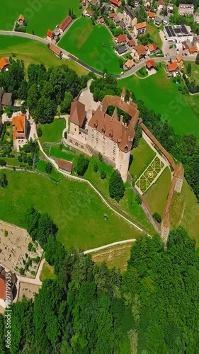 Medieval Swiss castle aerial view in summer. A drone flies through a green valley in the Swiss mountains. Famous Gruyere castle in Switzerland also called Schloss Greyerz, aerial shot by drone photo