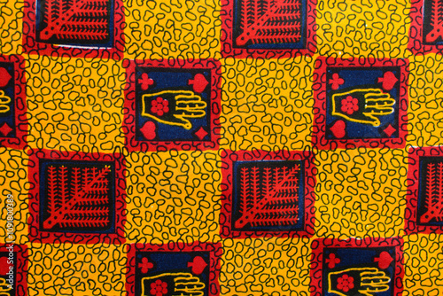 top view of red yellow ankara fabric, flatlay of nigerian wax cloth with designs, spread out red yellow ankara material photo