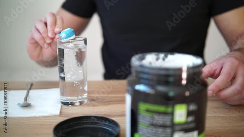 Young man prepares creatine in a glass of water