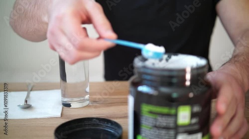Young man prepares creatine in a glass of water