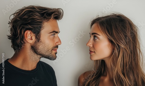 A man and woman facing each other, exchanging a thoughtful gaze. Capturing emotional connection and communication between people.