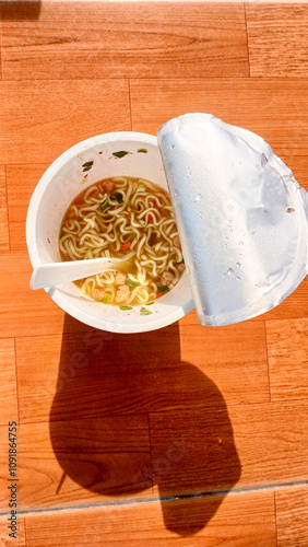 Blitar Indonesia, November 21, 2024: Cup instant noodles from Pop Mie products on a brown table background. photo