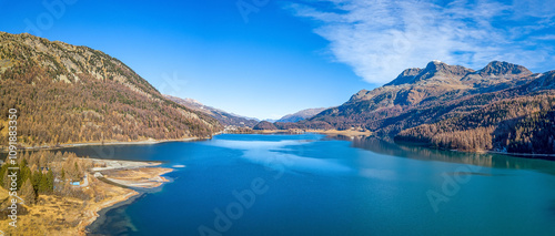 Aerial image of Silvaplanersee Lake with its turquoise water and mountains in autumn color photo