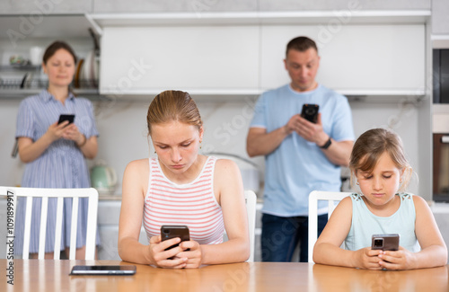 Portrait of happy children and parents using phones at home photo