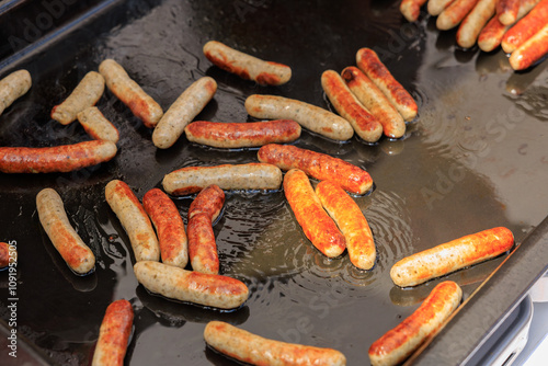 Close-Up of Grilled German Sausages on Hot Pan, Showcasing Traditional Street Food photo