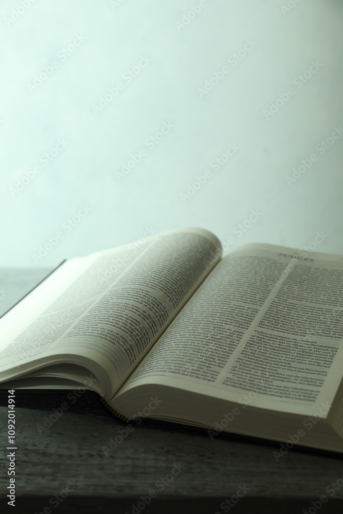 Obraz premium Open Holy Bible in English language on wooden table, closeup. Space for text