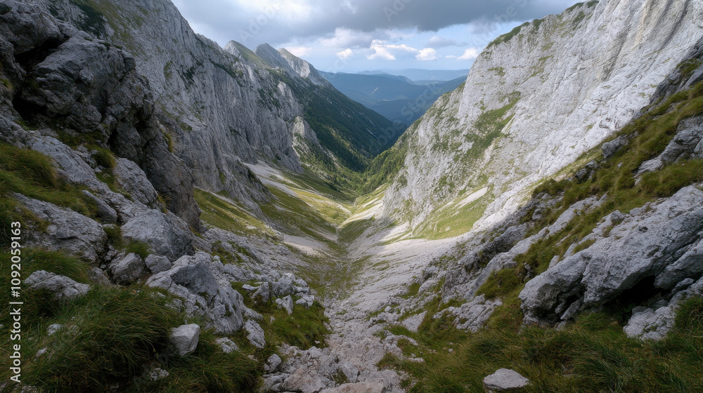 Obraz premium breathtaking view of rocky valley surrounded by steep mountains, showcasing natural beauty of landscape. sunlight casts dramatic shadows, enhancing rugged terrain
