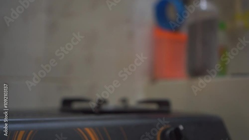 Man hand turning off the kitchen gas stove after cooking food. Gas stove with blue color flame.