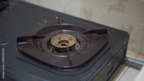 Man hand turning off the kitchen gas stove after cooking food. Gas stove with blue color flame.