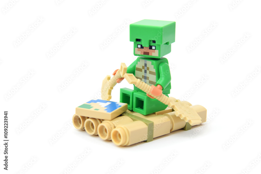 Naklejka premium Lego minifigure of popular game Minecraft on raft with pixel map. Editorial illustrative image of popular plastic toys.