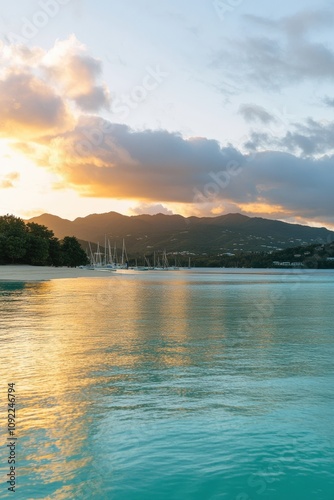 Serene sunset over tranquil bay with moored sailboats, reflecting golden light on calm waters and lush green hills.