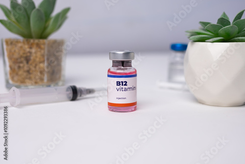 a liquid vitamin b12 with a syringe on the clinic table. health and medical concepts