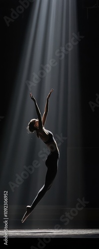 A dancer captures the essence of movement and grace, illuminated by beams of light in a dramatic setting. Her leap symbolizes freedom and artistic expression. photo