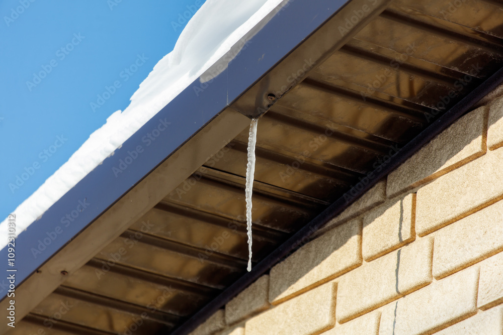 Fototapeta premium A roof with icicles hanging from it