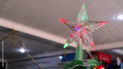 Christmas tree decoration with star top and colorful lights. Small decorated Christmas tree on a table in a room