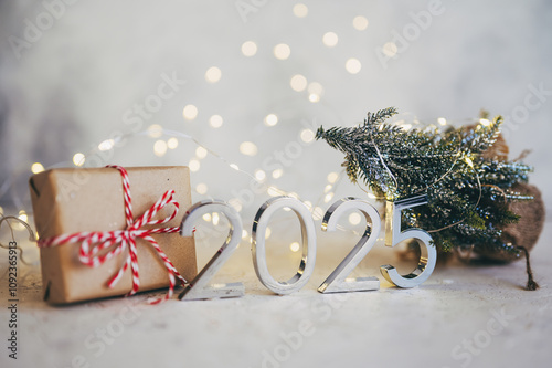 New Year's lights gold and dark red colors bokeh background with glowing number 2025 and fireworks. Happy New Year concept for 2025.