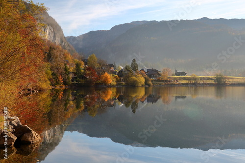Obraz na płótnie Colorful Autumn scenery on a misty morning and reflections on the Grundlsee lake (Eastern part), Salzkammergut, Styria, Austria, Europe, with the village Gossl w salonie