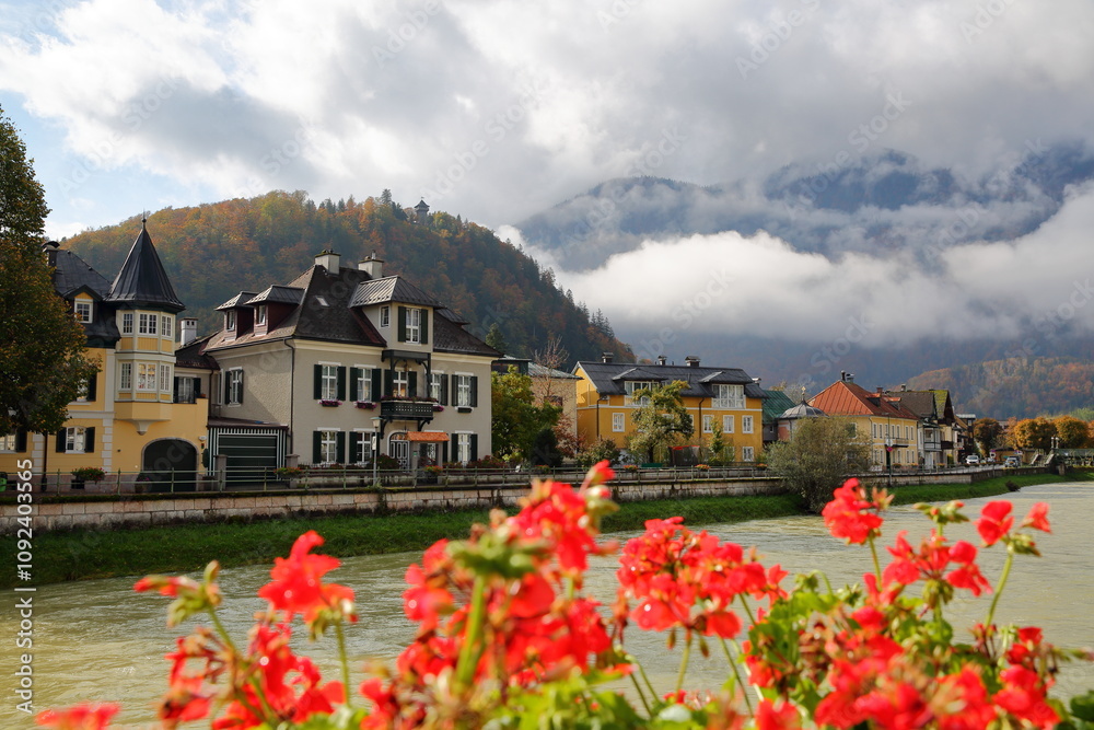 Heritage buildings located along the river Traun in Bad Ischl, Salzkammergut, Styria, Austria, Europe, with mountains and clouds in the background