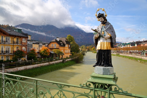 Obraz na płótnie The painted statue of Saint John of Nepomuk (erected in 1900), located on the Elisabeth Bridge over the river Traun in Bad Ischl, Salzkammergut, Styria, Austria, Europe, with heritage buildings on the w salonie