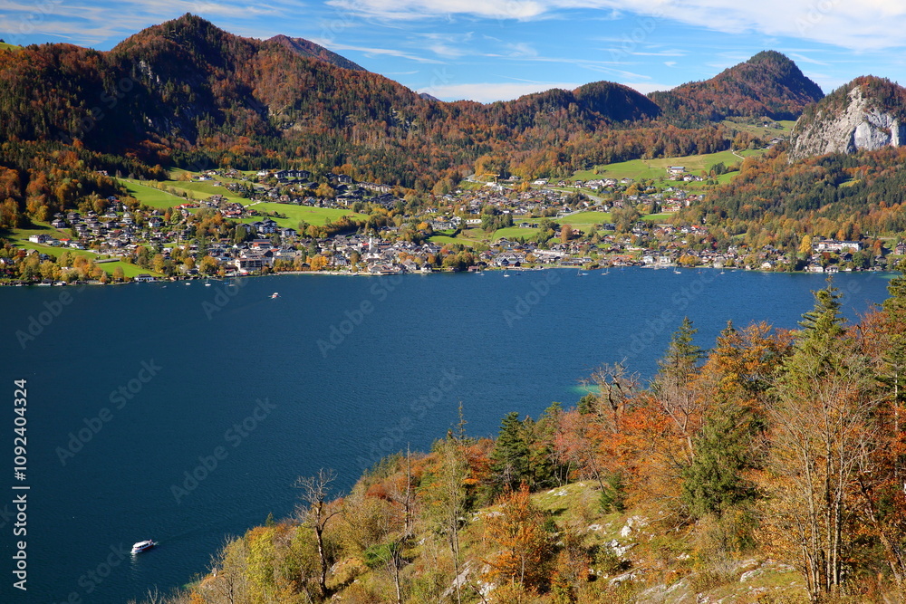 Colorful Autumn scenery and panoramic view on the lake Wolfgangsee towards Saint Gilgen, Salzkammergut, Styria, Austria, Europe. Picture taken from the viewpoint Sheffelblick, Falkenstein Rock