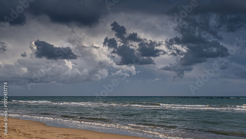 Heavy rain clouds at sunset hour by the sea in November as seen at the beach in Pervolia village, Larnaka District, Cyprus photo