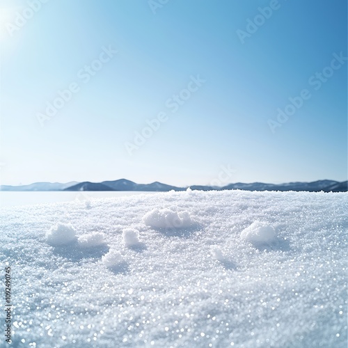 A minimalist display of untouched snow covering a smooth surface, with a few sparkling crystals highlighted, emphasizing the serenity and beauty of a snow-covered landscape. Product photography with