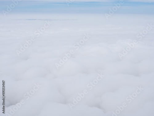 A vast expanse of stratocumulus clouds in shades of white and grey, covering the entire sky like a layer of fog, stratocumulus, perspective