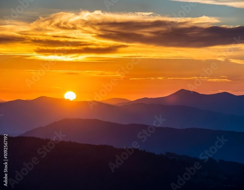 Dramatic Sunset Over Mountain Range with Vibrant Sky and Rolling Hills