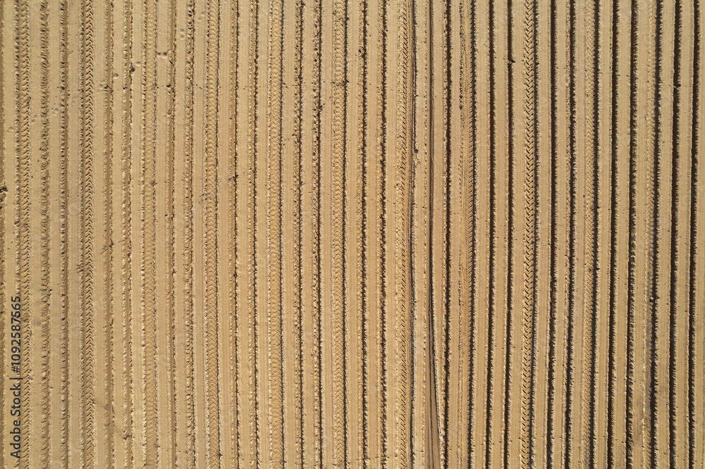 Selective blur on furrows on a Agricultural landscape near a farm, a plowed field in the countryside. The plough is a technique used in agriculture to fertilize a land. Selective blur on furrows on a Agricultural landscape near a farm, a plowed field in the countryside. The plough is a technique used in agriculture to fertilize a land.