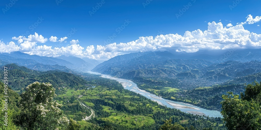 Fototapeta premium A sweeping landscape view of mountains, valleys, and rivers under a clear blue sky, with nature in full bloom.