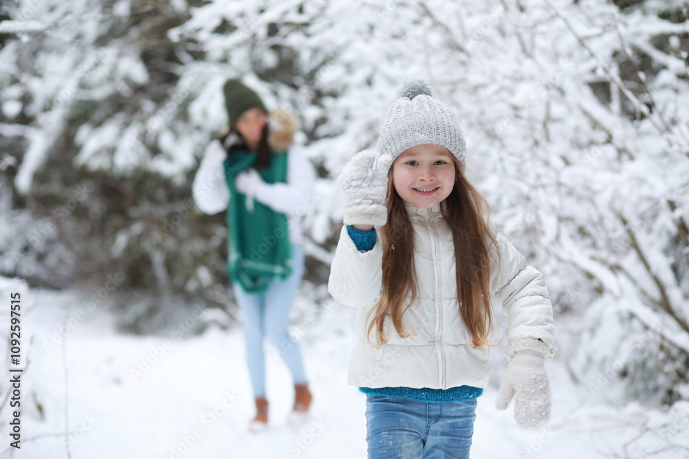 Young family for a walk. Mom and daughter are walking in a winter park. Young family for a walk. Mom and daughter are walking in a winter park.