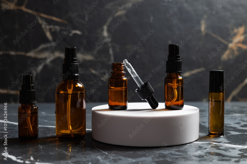 Amber bottles with facial cosmetics on the dark background Amber bottles with facial cosmetics on the dark background