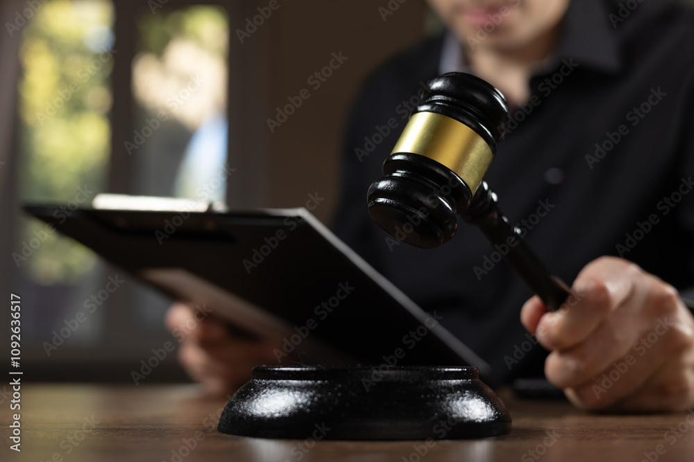 Judge with paper document pronouncing sentence in a court of law. Judge with paper document pronouncing sentence in a court of law.