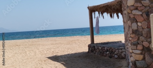 husha (hut) camp in Sinai with , in the bacgound the  Red Sea, clear pale blue sky photo