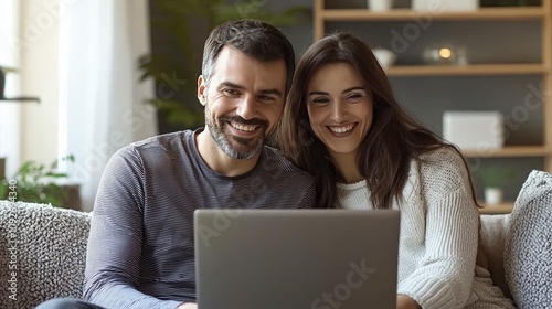 A couple sits closely together on a couch, sharing smiles and laughter as they look at their laptop, emphasizing their bond in a warm, inviting atmosphere.