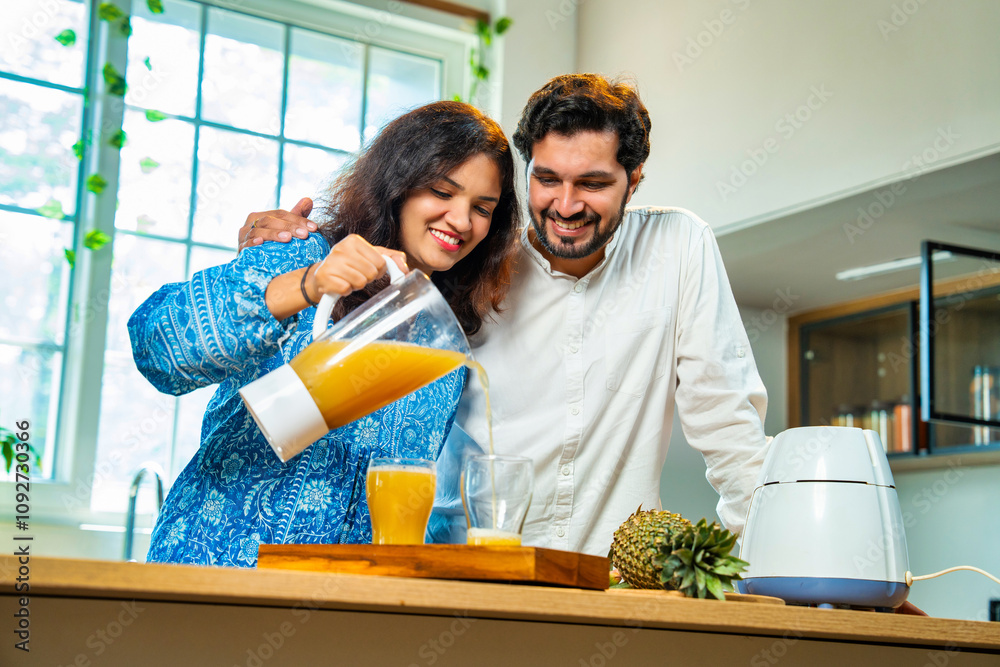 Indian asian couple bonding over fresh pineapple juice preparation, health and nutrition at home Indian asian couple bonding over fresh pineapple juice preparation, health and nutrition at home