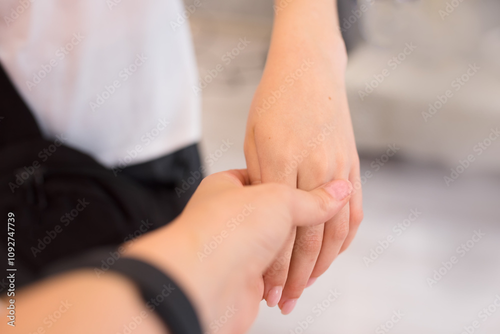 Female hands close-up, adult holding young girl's hand Female hands close-up, adult holding young girl's hand