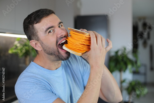 Man eating a gigantic cheese sandwich 