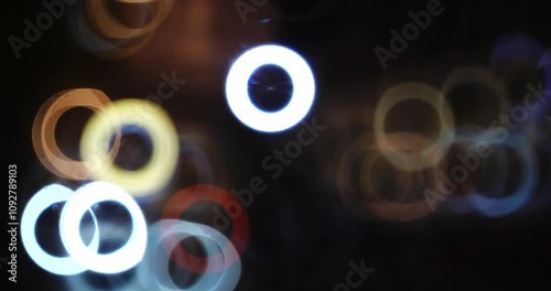 Defocuse, donut shaped bokeh car headlights and taillights at night in a busy city junction. Top view, real time, no people