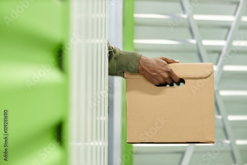 Schilderij op canvas Close up on hands of Black man carrying cardboard box filled with personal belon