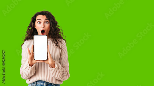 surprised shocked woman showing mobile phone in front on green screen background