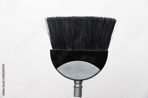 Gray plastic broom on white background with copy space. House cleaning concept