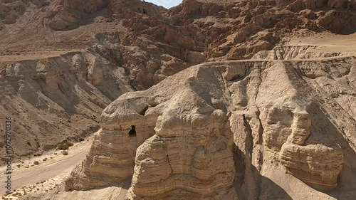The caves and desert surrounding Qumran Nature Reserve, where the ancient Dead Sea Scrolls were discovered, on a dry summer day, highlighting their historic and sacred significance.