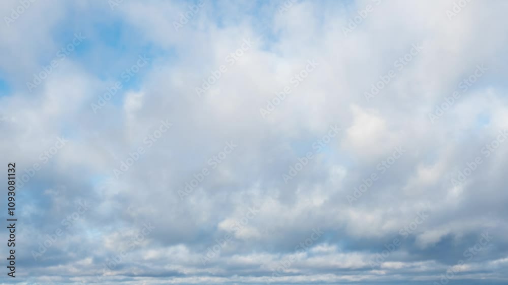 Time lapse of white and dark gray fluffy clouds moving fast in the blue sky on the horizon. Natural background, 4K resolution.