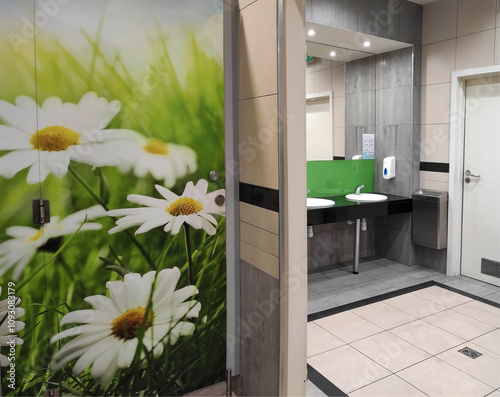 modern public toilet interior. women toilets with green doors with daisies. commercial bathroom