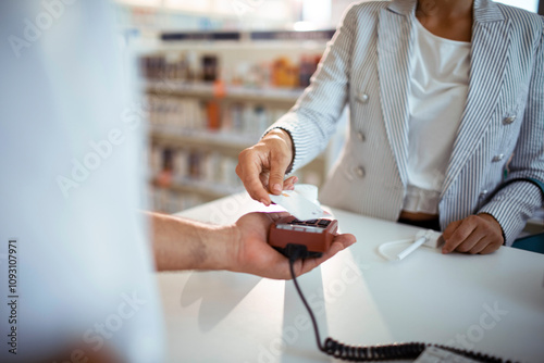 Woman making contactless smartphone payment at pharmacy photo