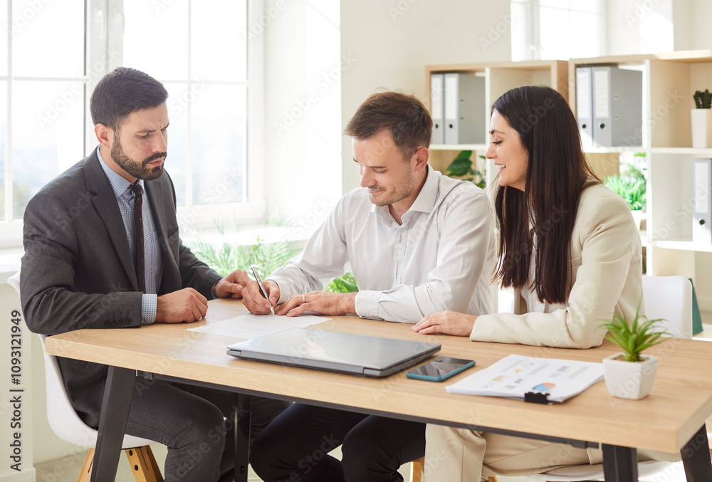 Positive married couple signing a contract with a real estate agent or professional consultant during a meeting in an office. Client services, financial investments, and business trust. Positive married couple signing a contract with a real estate agent or professional consultant during a meeting in an office. Client services, financial investments, and business trust.