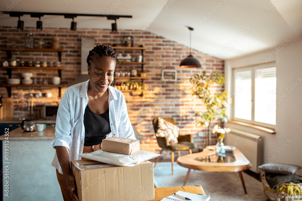 Young woman opening up the package she received in the mail at home in th ekitchen Young woman opening up the package she received in the mail at home in th ekitchen